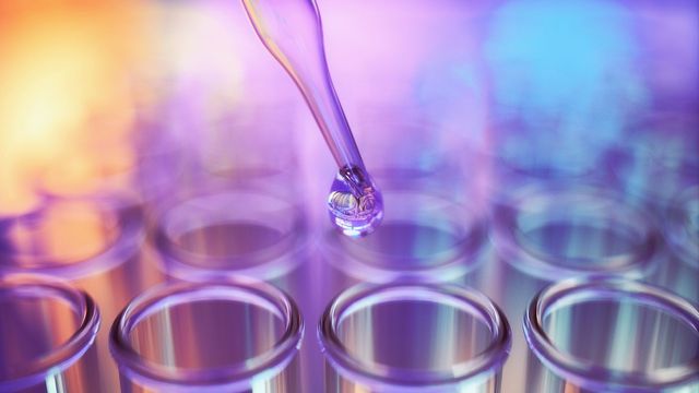 Close-up of pipette dispensing liquid into test tubes, symbolizing innovation in liquid biopsy for cancer diagnostics. 