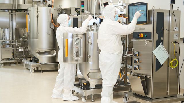 Scientists wearing PPE working in ReiThera's bioprocessing facility. 