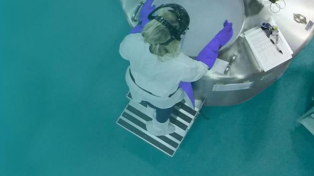 Lab worker pouring a substance into a container 
