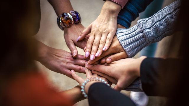 Diverse hands stacked together symbolizing inclusion in drug discovery and FDA trials 